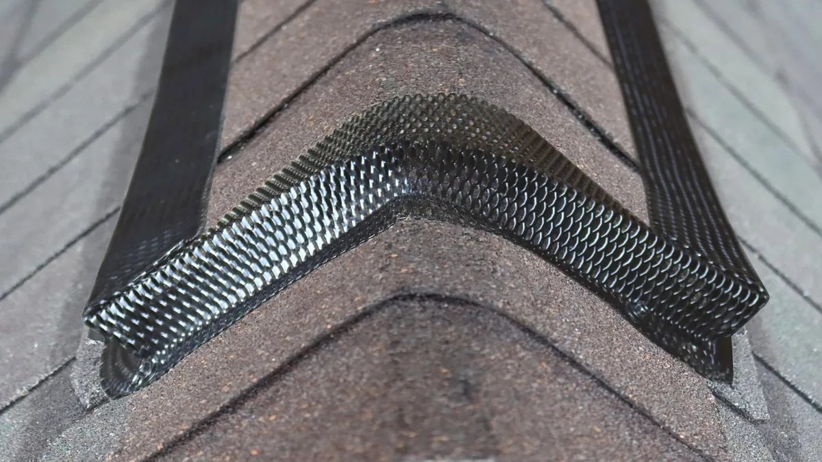 Black mesh guard installed along a roof ridge vent