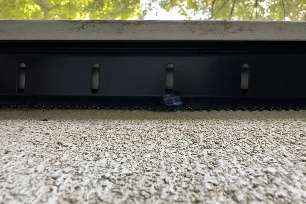 Black metal guard installed along the bottom edge of a home's siding