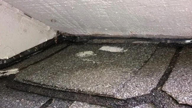 Clear sealant filling a gap where a roof meets a wall