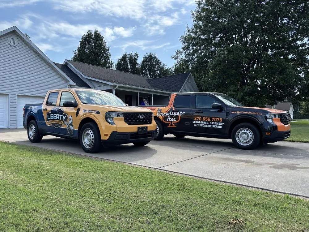 Liberty Pest Control and The Crawlspace Ace trucks parked in a home's driveway