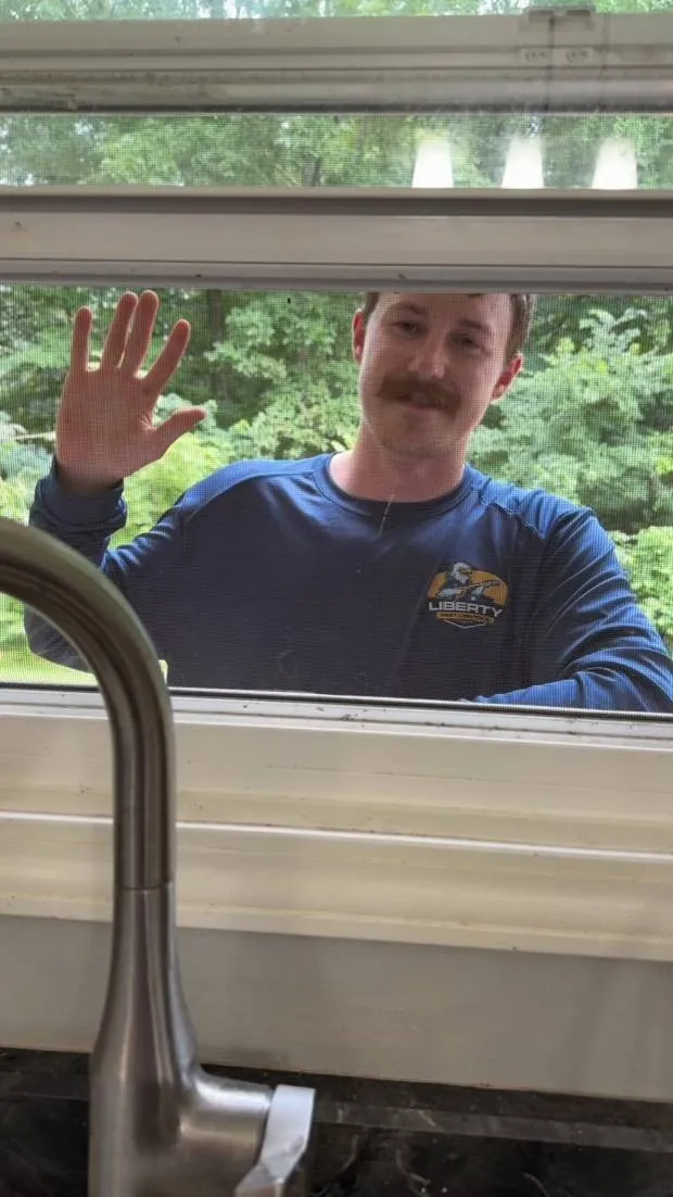 Liberty Service Specialist waving through a kitchen window