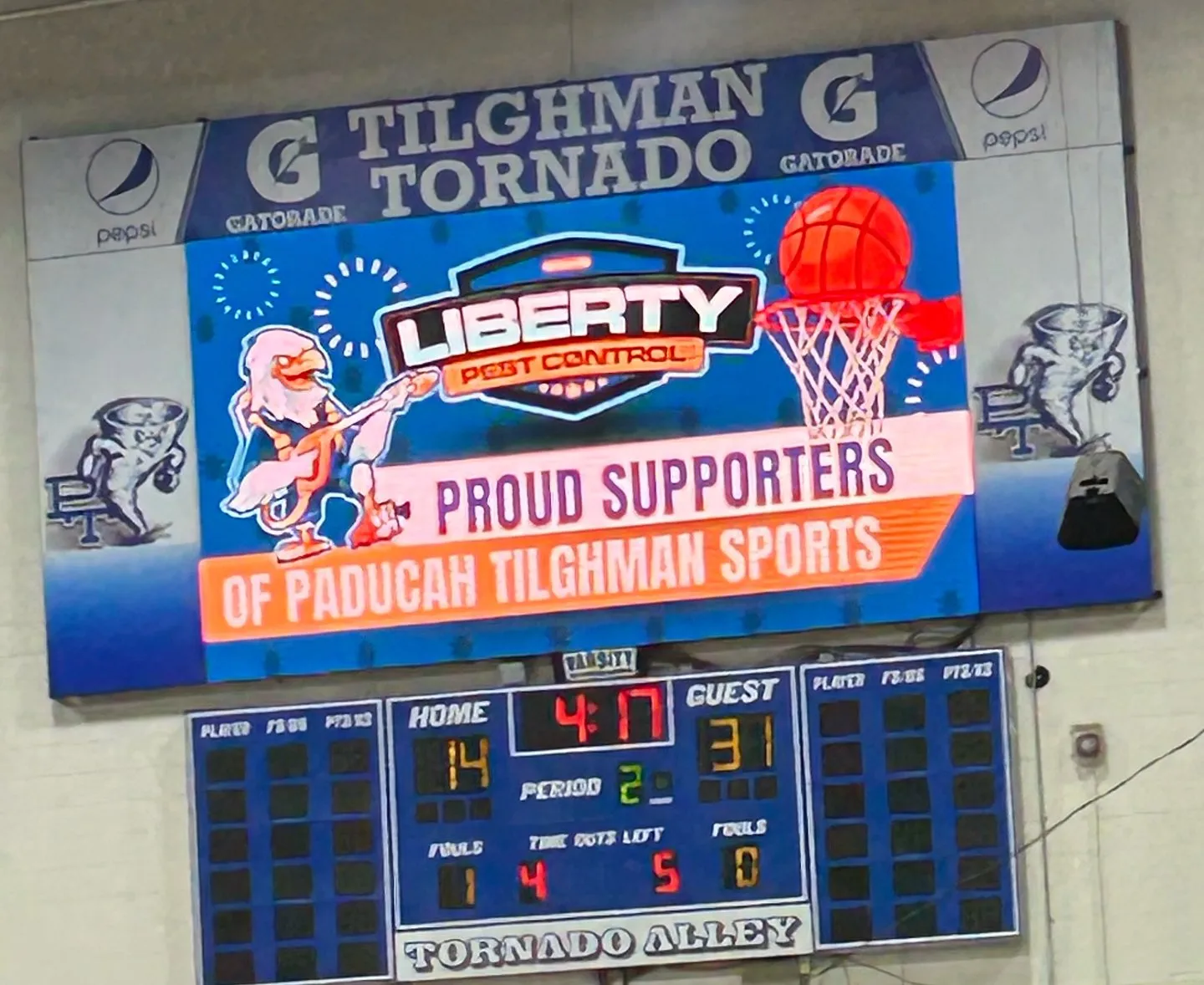 Liberty Pest Control sign on a gym scoreboard: Proud supporters of Paducah Tilghman Sports
