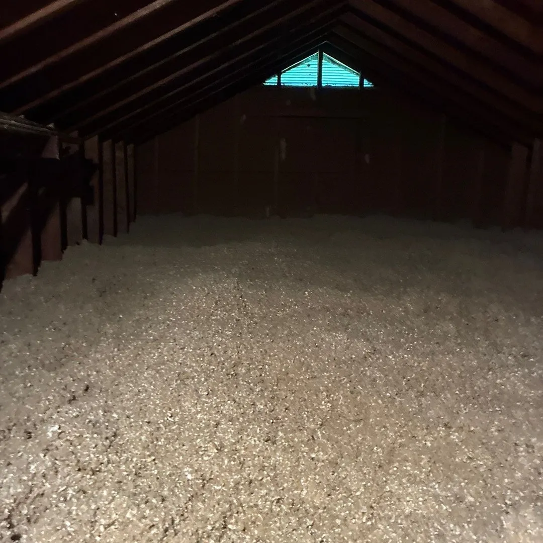 Freshly blown-in insulation covering an attic floor