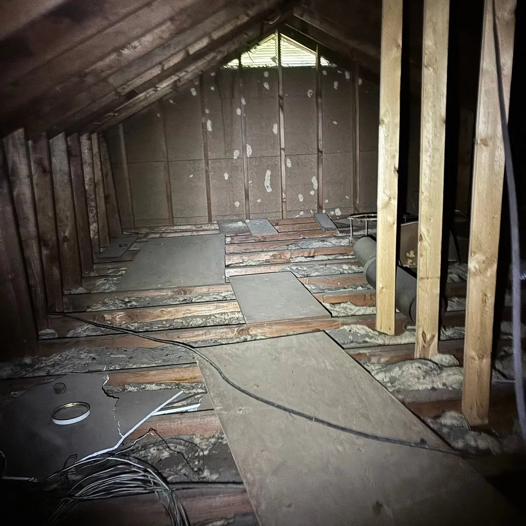 Thin, patchy old insulation between exposed attic joists
