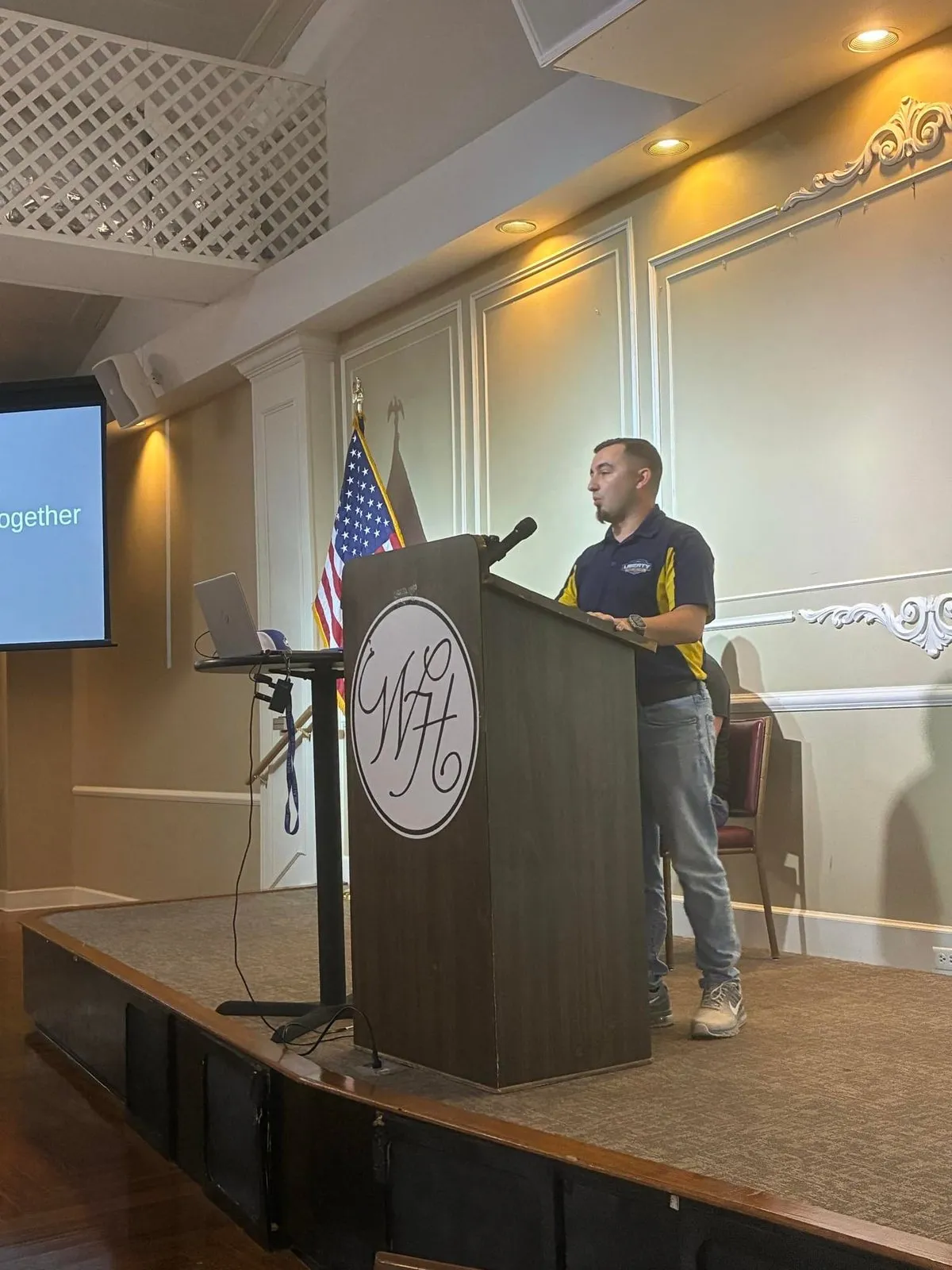 John Stopka speaking at a podium at a realtor association event