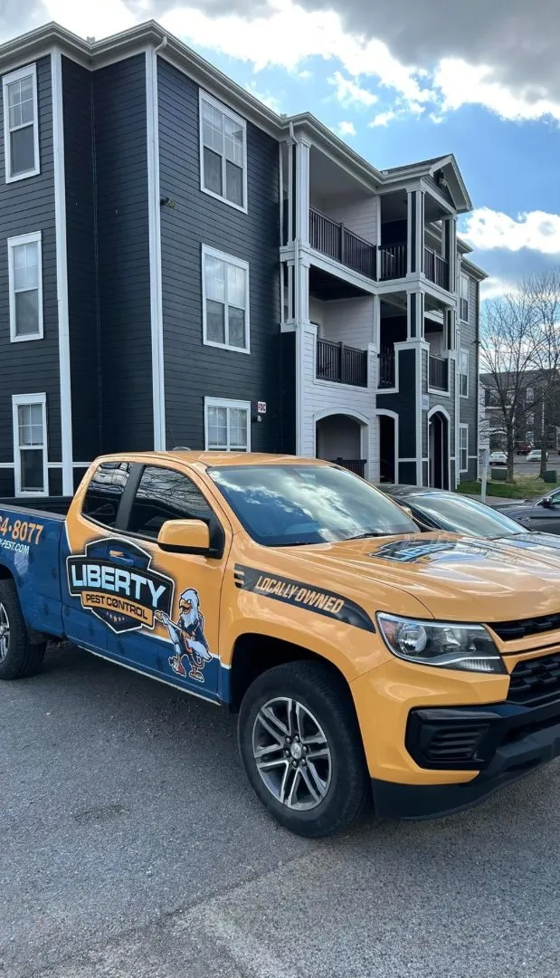 Liberty Pest Control pickup truck parked outside an apartment building